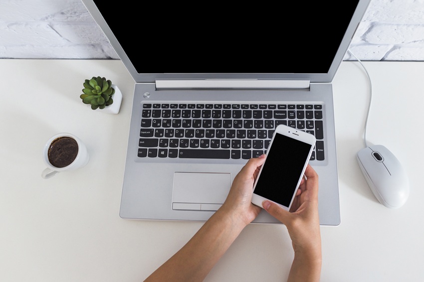 kobieta używająca telefonu i laptopa